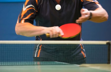 Man serving underhand backspin in table tennis